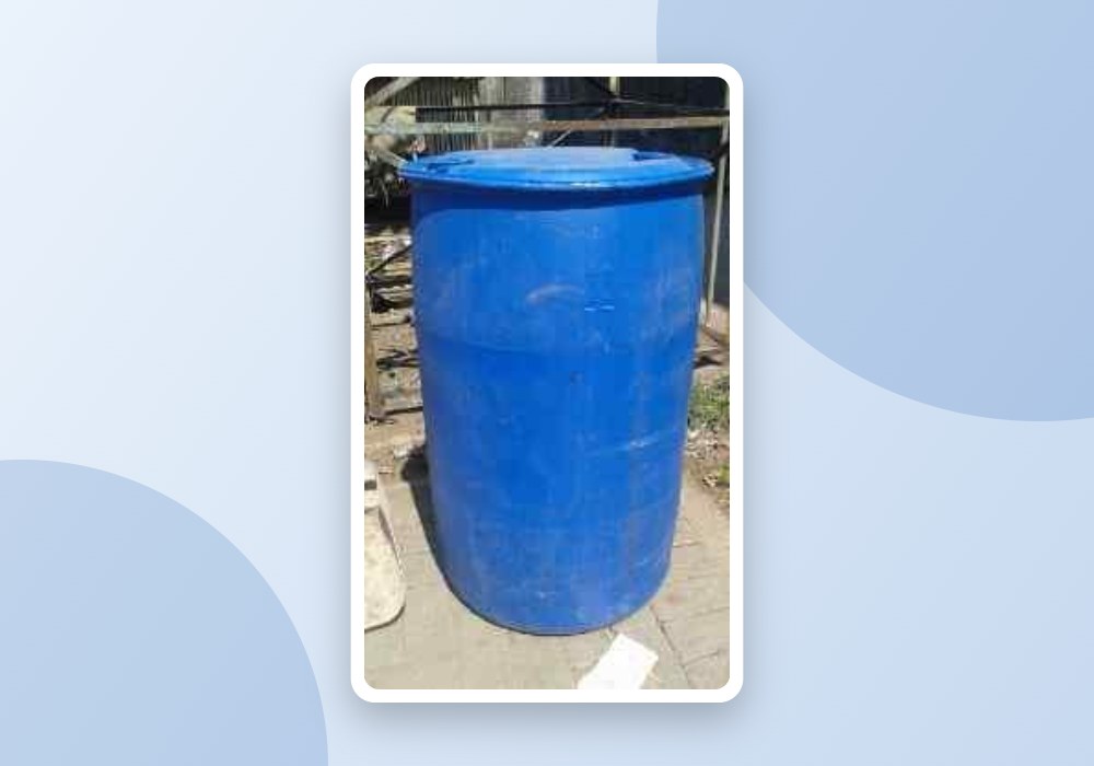 Drum biru plastik dipakai sebagai penampung air di luar ruangan